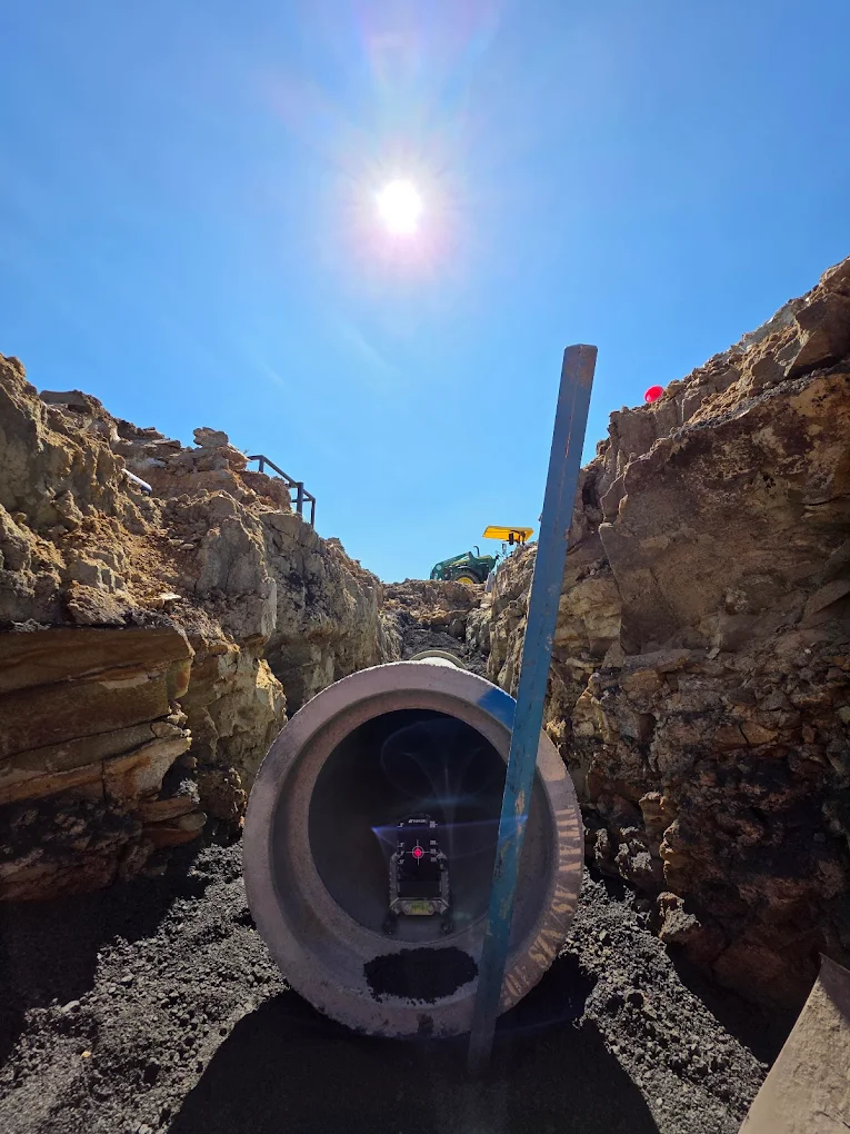 Large diameter drainage pipe being laid in excavated trench